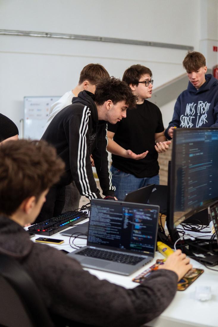 Tím pri monitoroch spolu rieši úlohu na hackathone